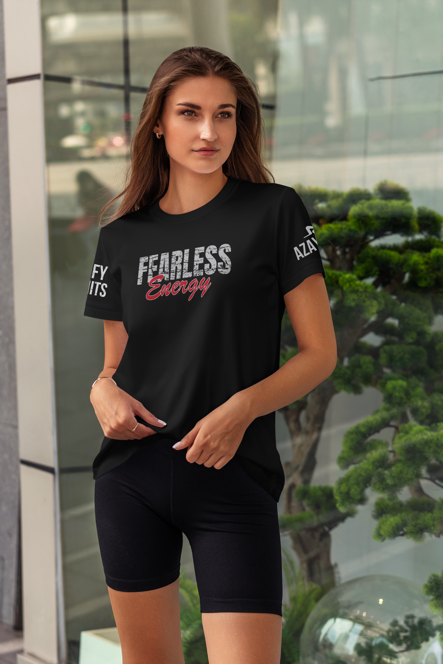 Woman wearing a black t-shirt with 'Fearless Energy' text, standing indoors.