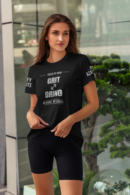 Woman wearing a black t-shirt with motivational text, standing in front of a glass wall with greenery.