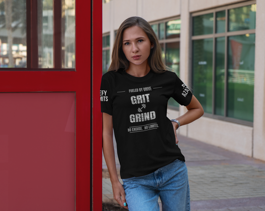 model wearing black tee with the text grit and grind leaning against a red door