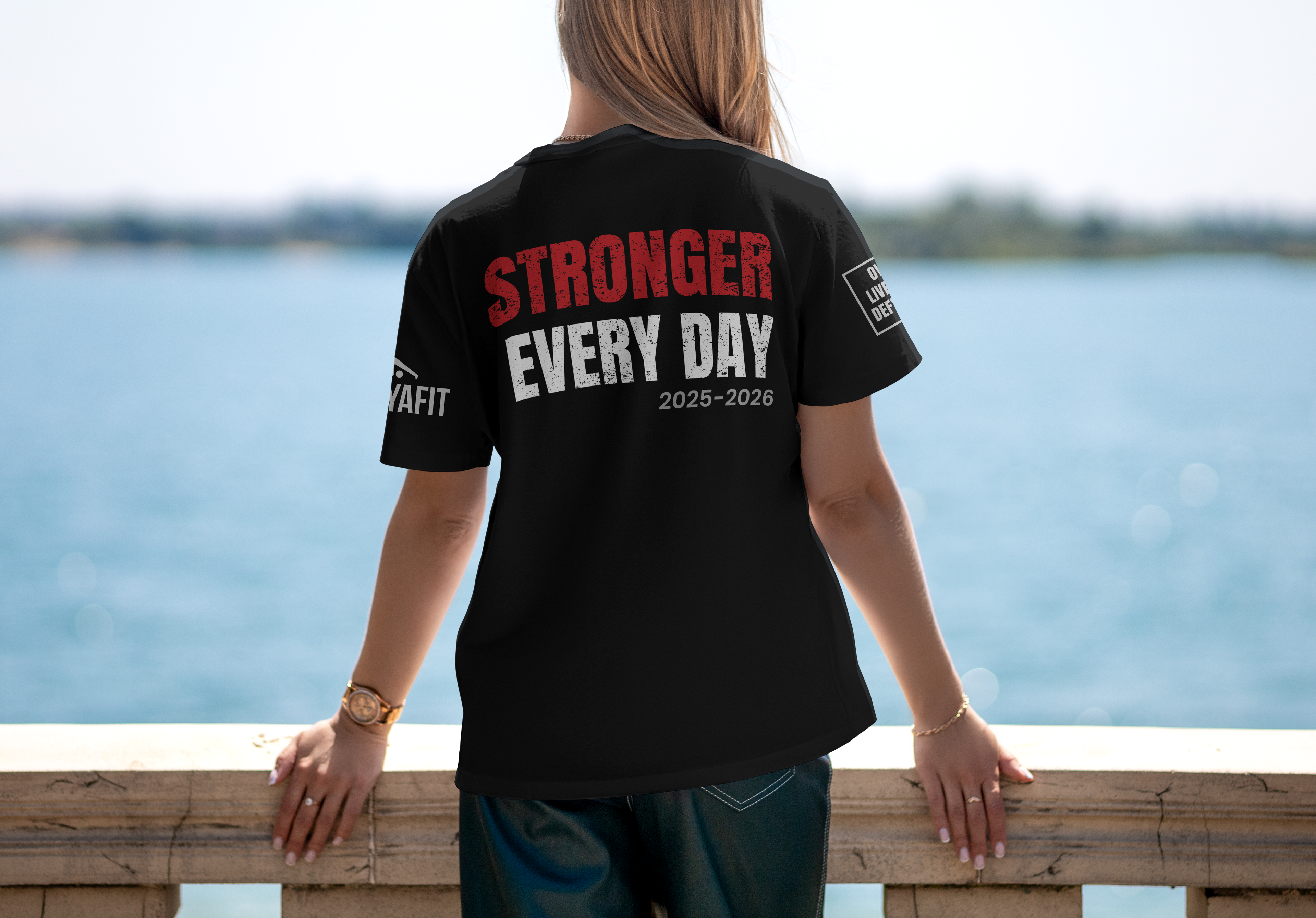 Stronger Together custom team t-shirt for teachers, black performance tee, motivational text on back, worn by person by a body of water