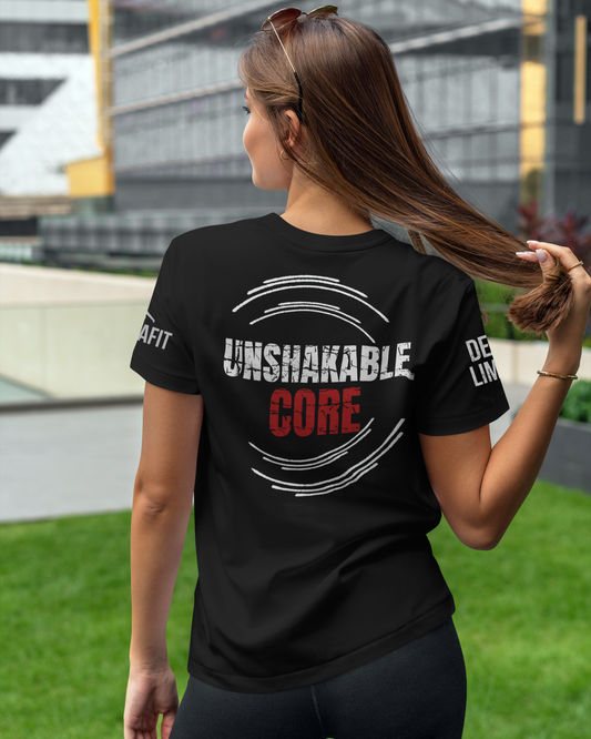 Woman wearing a black t-shirt with 'Unshakable Core' text outdoors.