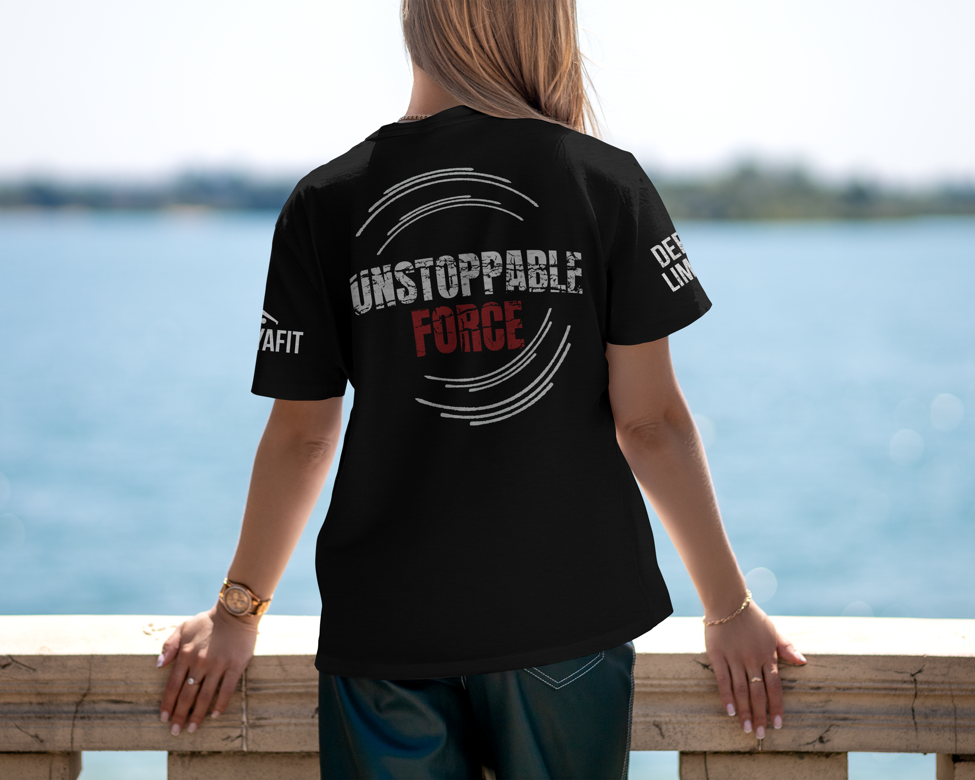 model wearing black tee with unstoppable force text while looking over a bridge