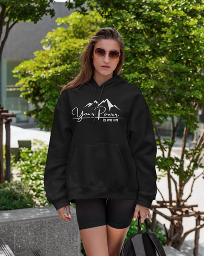 Woman wearing a black hoodie with 'Your Power is Within' text, holding a backpack