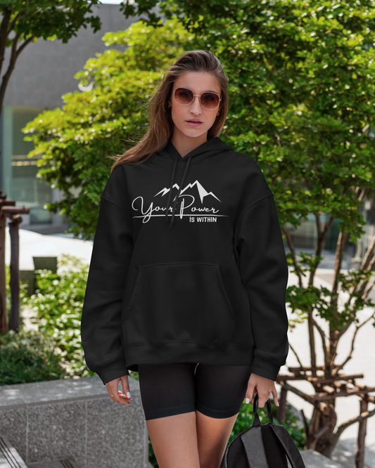 Woman wearing a black hoodie with 'Your Power is Within' text, holding a backpack