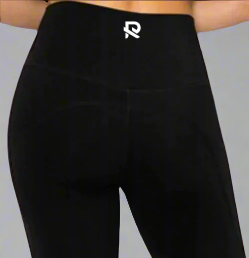 Close-up back view of black leggings featuring an "R" logo centered on the waistband. Designed for a sleek fit and comfortable support, perfect for workouts and everyday wear.