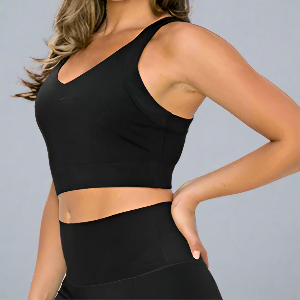 Side view of a model wearing a black sports bra, with her face cropped out. This stylish and supportive sports bra offers a comfortable fit, perfect for workouts and everyday activewear.
