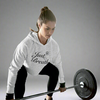 Woman lifting weights while wearing a heather grey crop hoodie, designed for comfort, style, and performance during workouts.