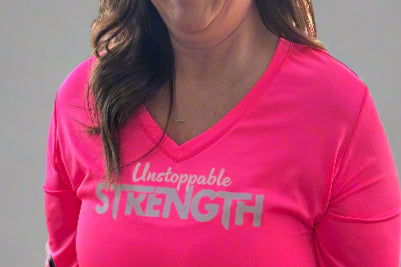Close-up view of the hot pink Unstoppable Strength long sleeve performance top, highlighting its fabric and design details.