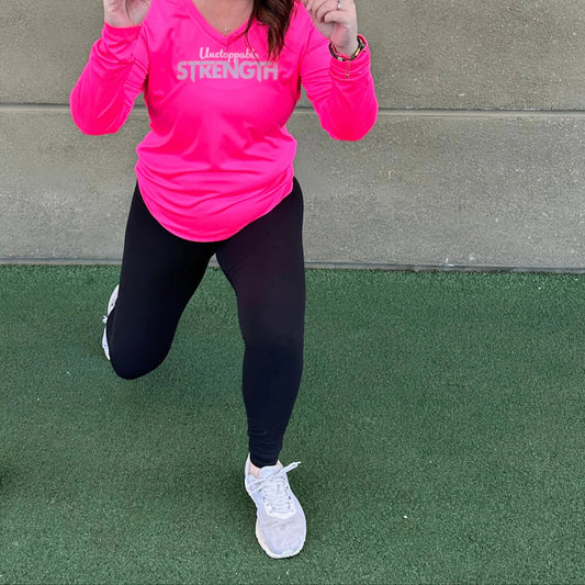 Woman lunging in a hot pink Unstoppable Strength long sleeve performance top, showcasing movement and comfort.