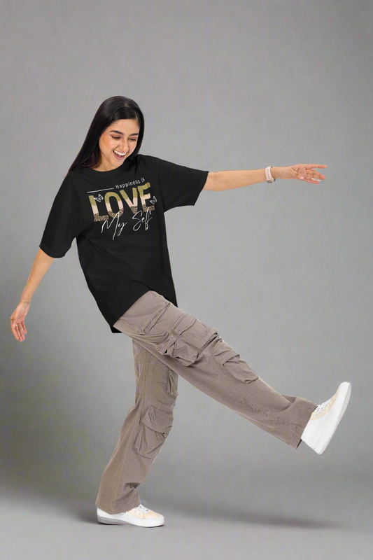 Cheerful woman having fun in a studio while wearing a black Love Myself unisex T-shirt. This soft, comfortable tee promotes self-love and confidence, perfect for casual and active wear.
