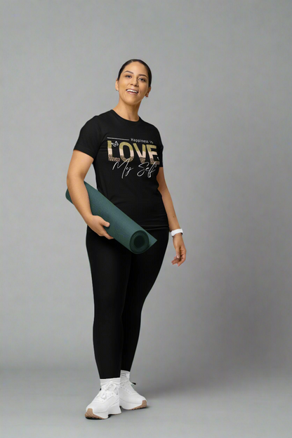 Smiling woman carrying yoga gear in a studio while wearing a Love Myself unisex T-shirt. This soft, comfortable tee promotes self-love and confidence, perfect for both workouts and casual wear.
