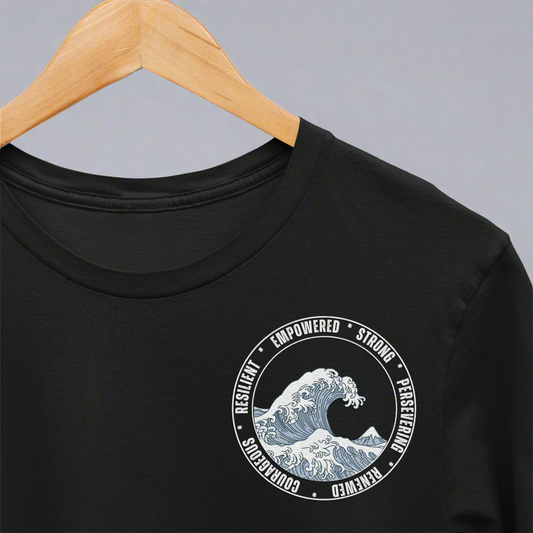 Wave of Strength T-shirt with a small front chest design, displayed on a wooden hanger against a wall, showcasing a minimalist and powerful style.